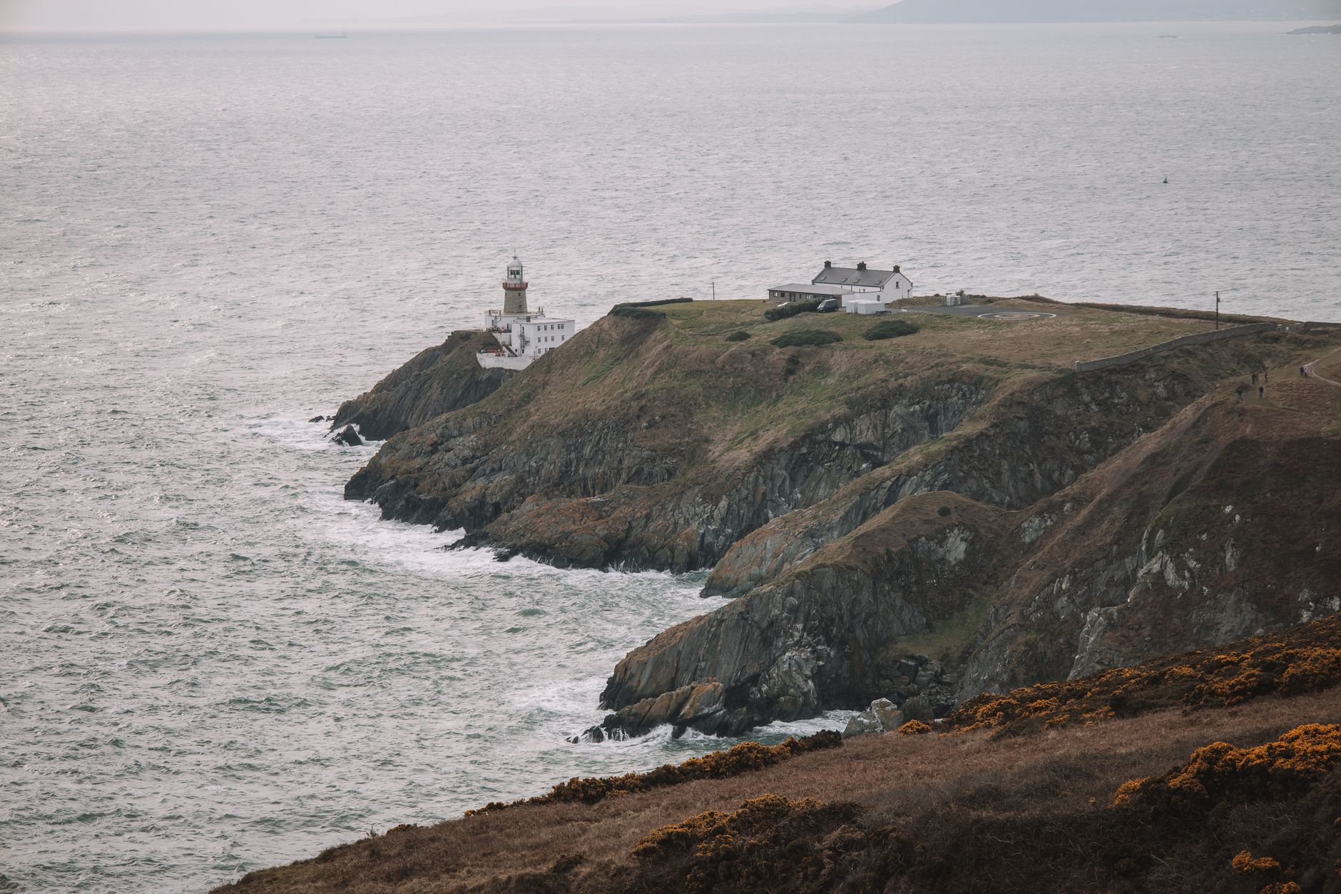Stunning coastal view of Baily Lighthouse on Howth Head, Dublin, Ireland. Dramatic cliffs meet the vast sea. — photograph by Joaquin Carfagna on Pexels