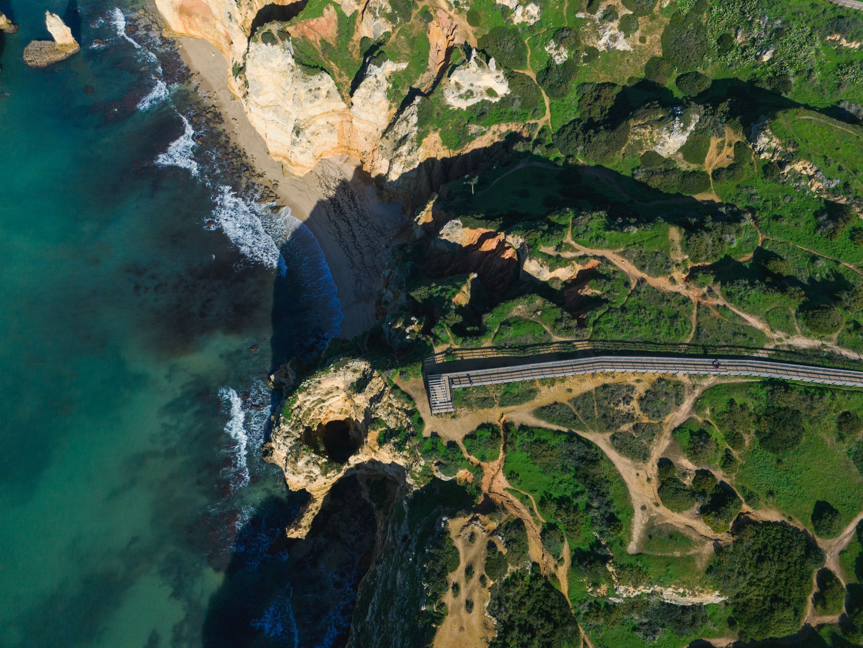 Stunning aerial view of Algarve's coastline in Lagos, Portugal showing cliffs, beach, and clear blue water. — photograph by Efrem  Efre on Pexels